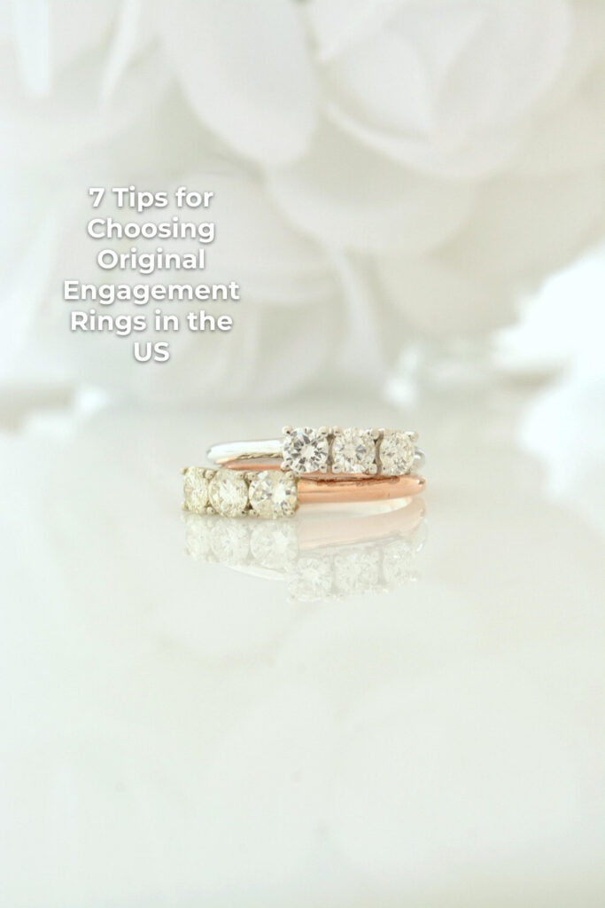 Original engagement rings with clear stones on a reflective surface against a light background