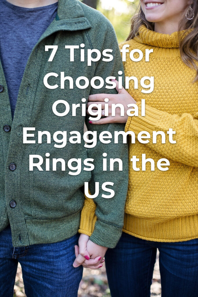 Original engagement rings shown on woman's hand as couple holds hands outdoors in sweaters and jeans