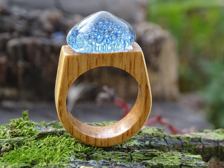 Quirky engagement rings: wooden ring with blue glass dome on a mossy tree stump