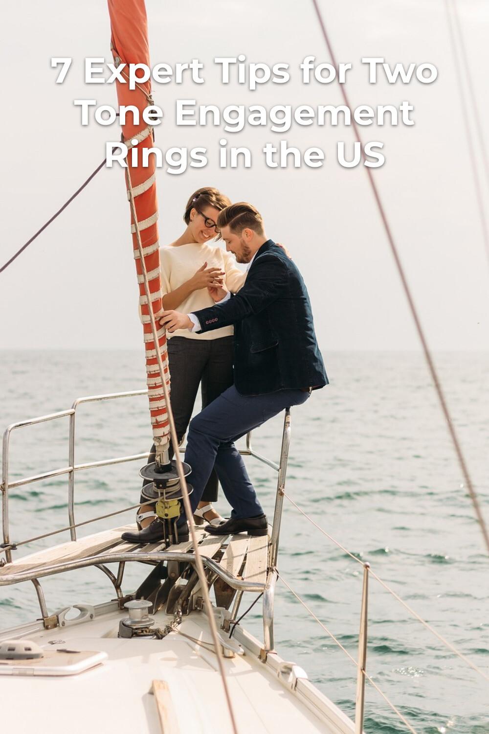 Two tone engagement rings proposal on a sailboat deck, man kneeling as woman stands by the sea