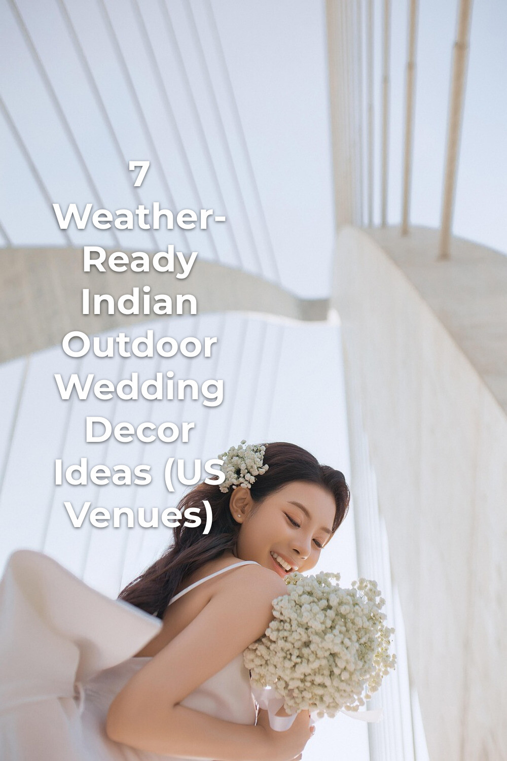 Indian outdoor wedding decor inspiration: woman in white dress holding a white flower bouquet under a cable bridge