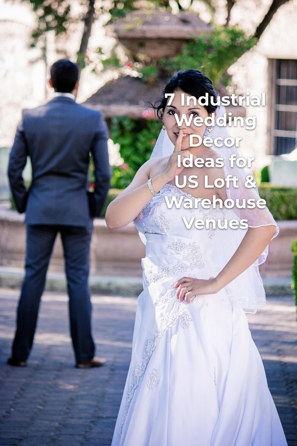 Industrial wedding decor editorial photo of bride in veil shushing as groom in suit faces away in garden