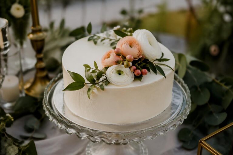 Elegant one tier wedding cake with white buttercream and fresh flowers for an intimate wedding celebration