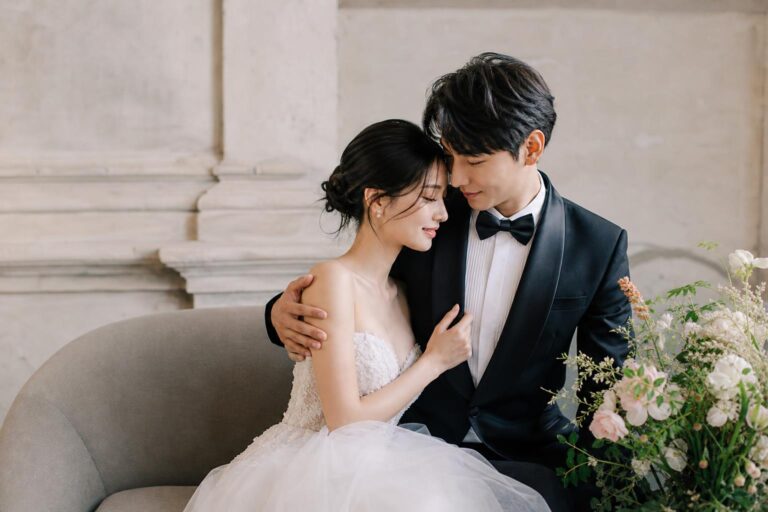 Cupal photo shoot of a stylish couple in wedding attire, blending editorial posing with soft romantic light
