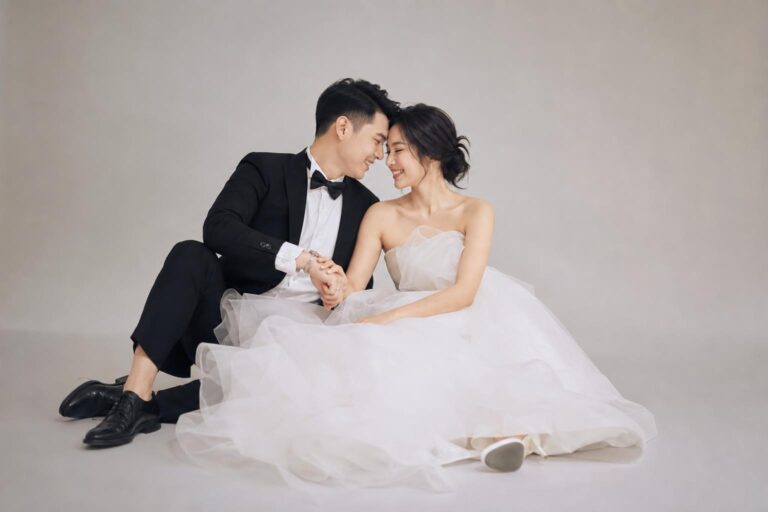 Studio prewedding photo ideas with an editorial feel, couple posing in a minimalist studio with soft lighting and seamless backdrop