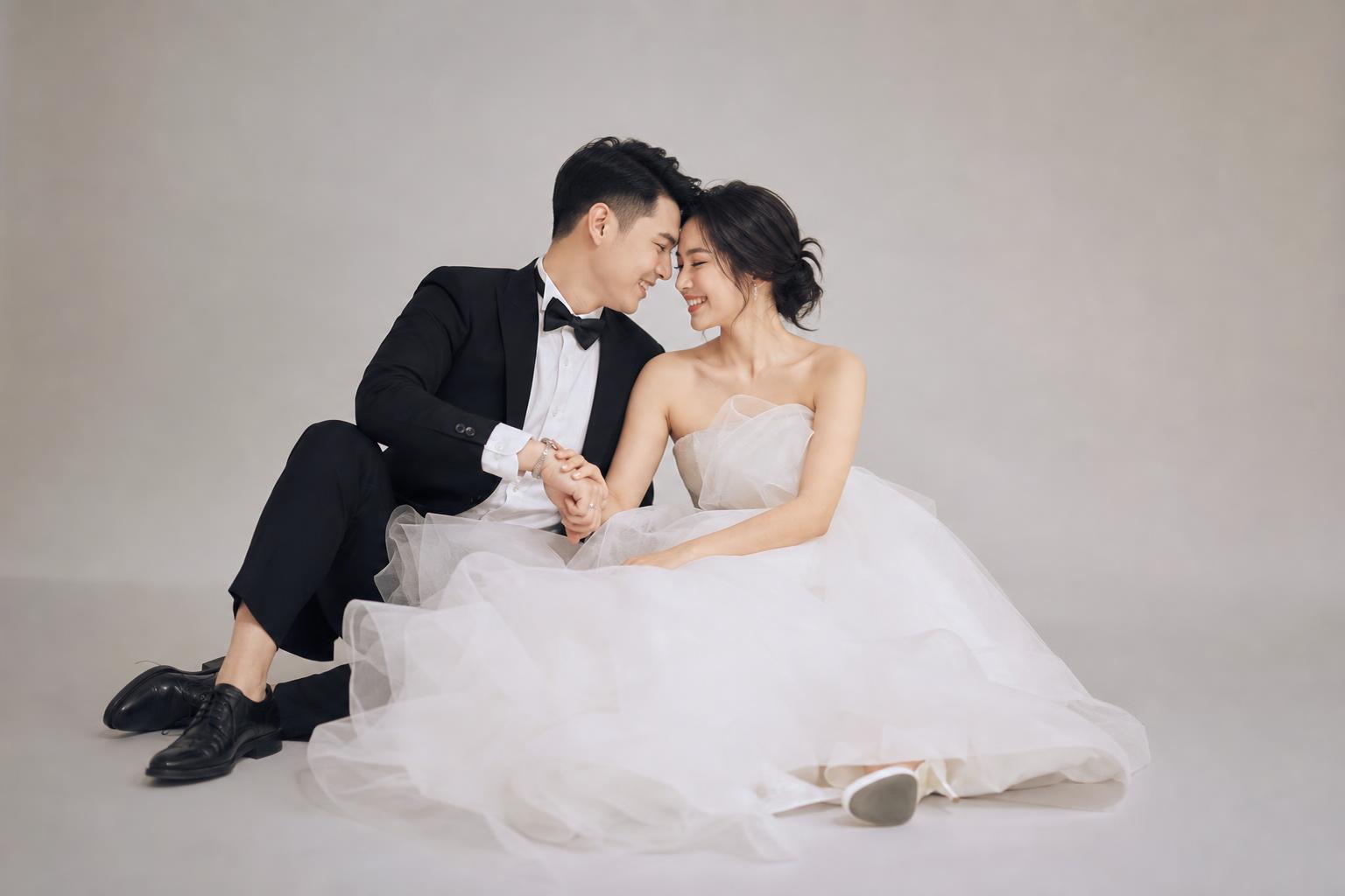 Studio prewedding photo ideas with an editorial feel, couple posing in a minimalist studio with soft lighting and seamless backdrop
