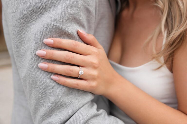 Engagement photo nails ideas with soft neutral manicure and diamond ring close-up in natural spring light