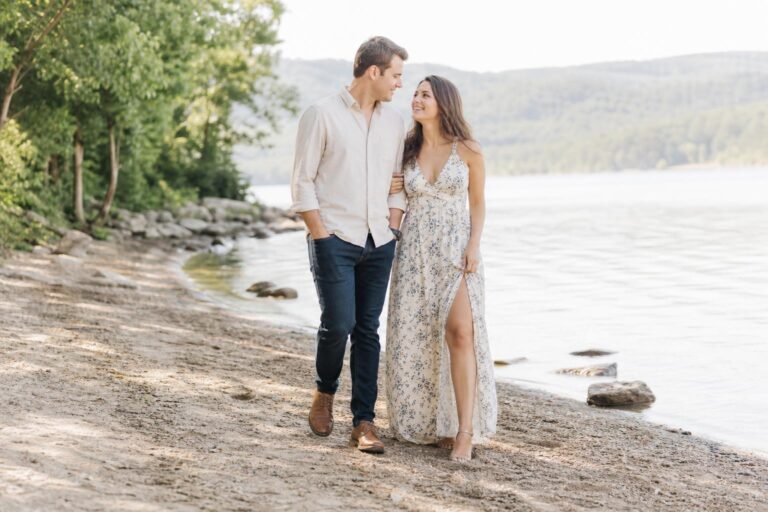 Engagement photo outfit ideas with a couple in neutral tones, her flowy midi dress and his crisp button-down in a garden setting
