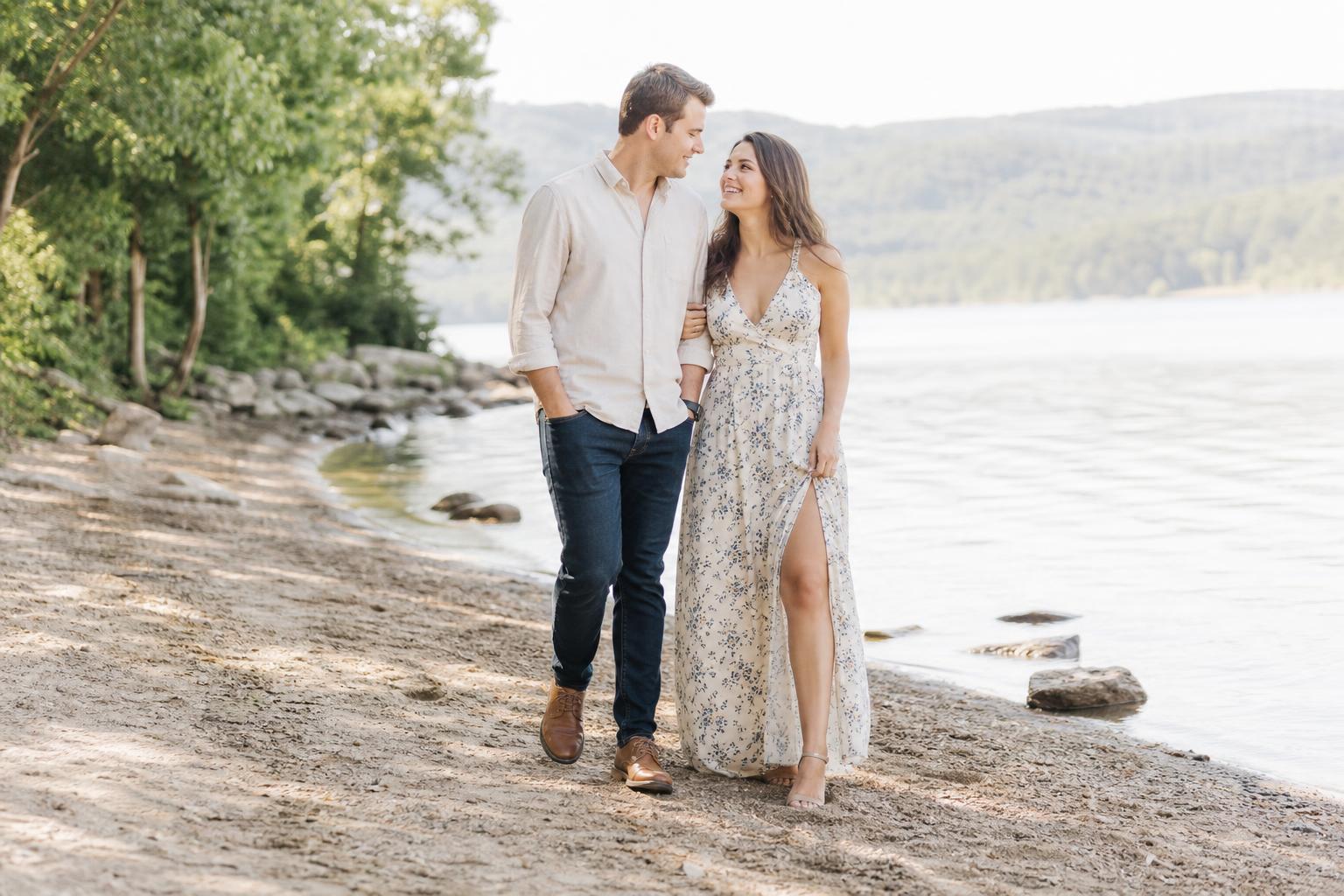 Engagement photo outfit ideas with a couple in neutral tones, her flowy midi dress and his crisp button-down in a garden setting