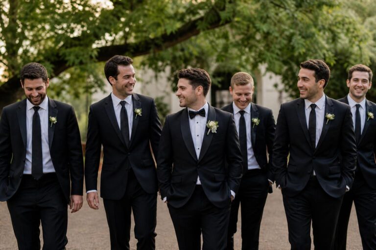 Modern groomsmen photo ideas with groom and friends in tailored suits walking together in soft natural light