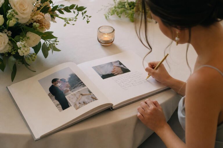 Romantic photo guest book with linen cover open on a wedding welcome table, featuring photos and space for handwritten notes