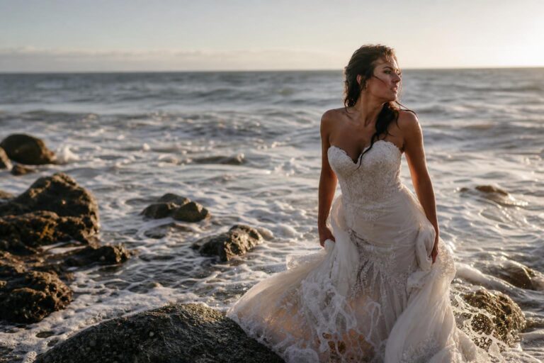 Bride in a wedding gown at sunset on a beach during a trash the dress photo shoot