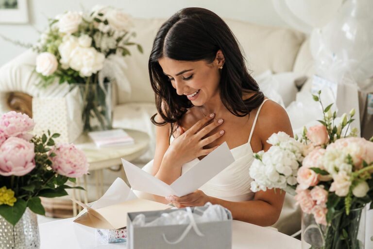 Bridal shower card ideas with elegant floral stationery and a handwritten note beside a gift on a bright table