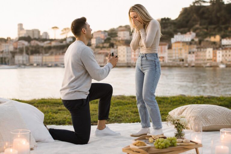 Cute proposal ideas: partner kneeling with engagement ring in a cozy apartment with breakfast tray, candles, and flowers