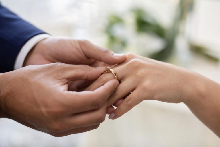 Close-up of a gold wedding ring with name engraving on a soft bridal background