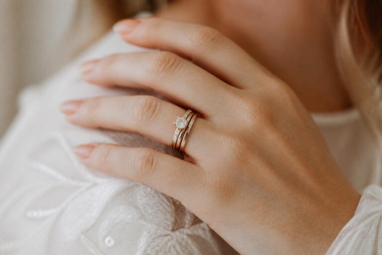 Minimalist wedding ring stack on a bride’s hand with slim bands and soft natural light, quiet bridal appeal