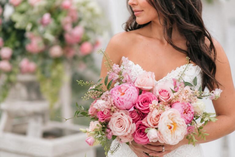 Pink wedding flowers in a refined blush bridal bouquet with roses, peonies, and greenery, photographed in soft spring light