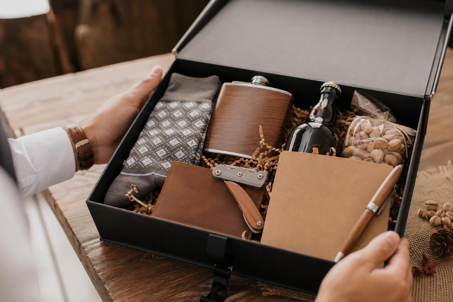 Refined groomsmen proposal box ideas with cufflinks, dress socks, tie bar, and whiskey mini in a matte gift box