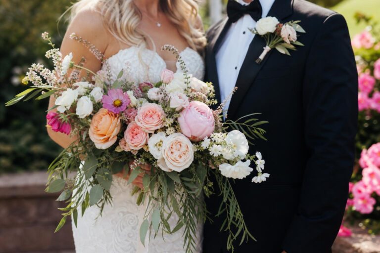 Summer wedding flowers in a romantic bridal bouquet with roses, dahlias, and eucalyptus greenery in warm natural light