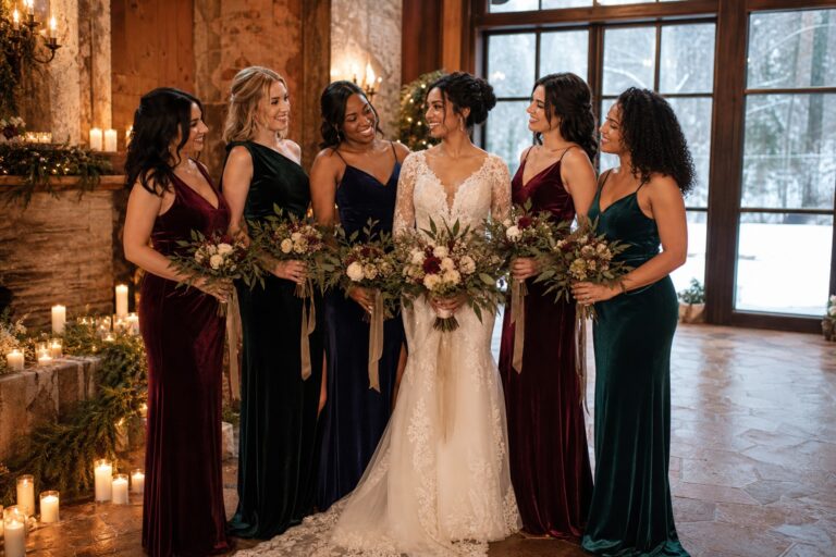 winter wedding bridesmaids in jewel-tone gowns at a candlelit venue